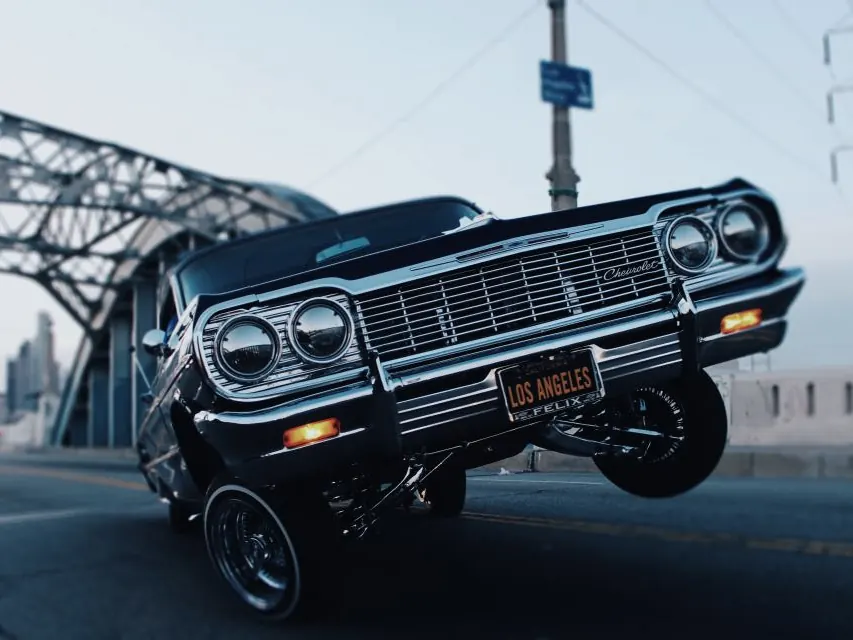 Classic American lowrider on a Los Angeles street with a bridge in the background