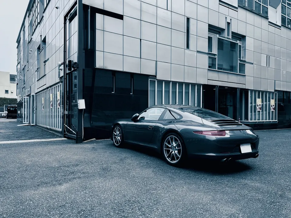 Imported grey sports coupe parked beside a modern building