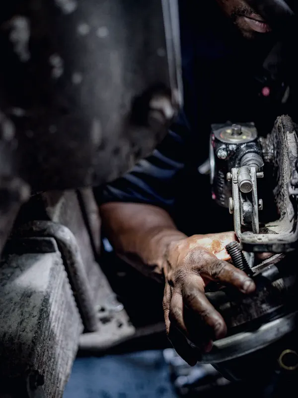 A technician's hands working inside an engine compartment